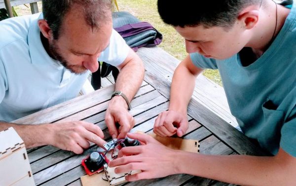 Man and teenage boy working on Bluetooth speakers