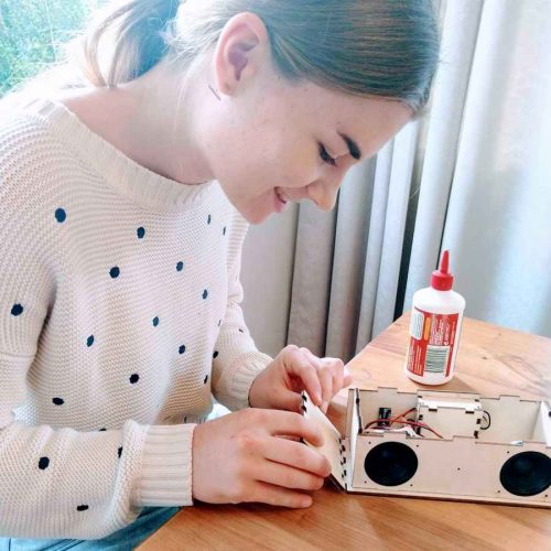 Teenage girl making a bluetooth speaker kit from SharperTHinker.